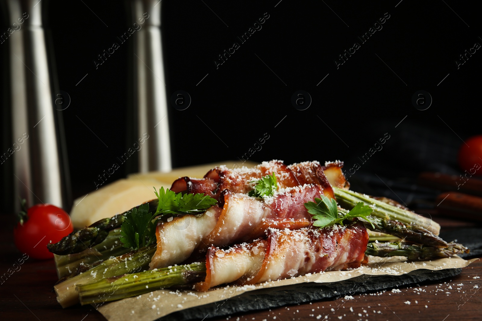 Photo of Oven baked asparagus wrapped with bacon on wooden table