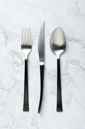 Stylish cutlery on white marble table, flat lay