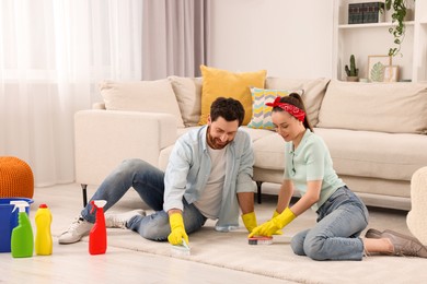 Photo of Spring cleaning. Couple tidying up living room together