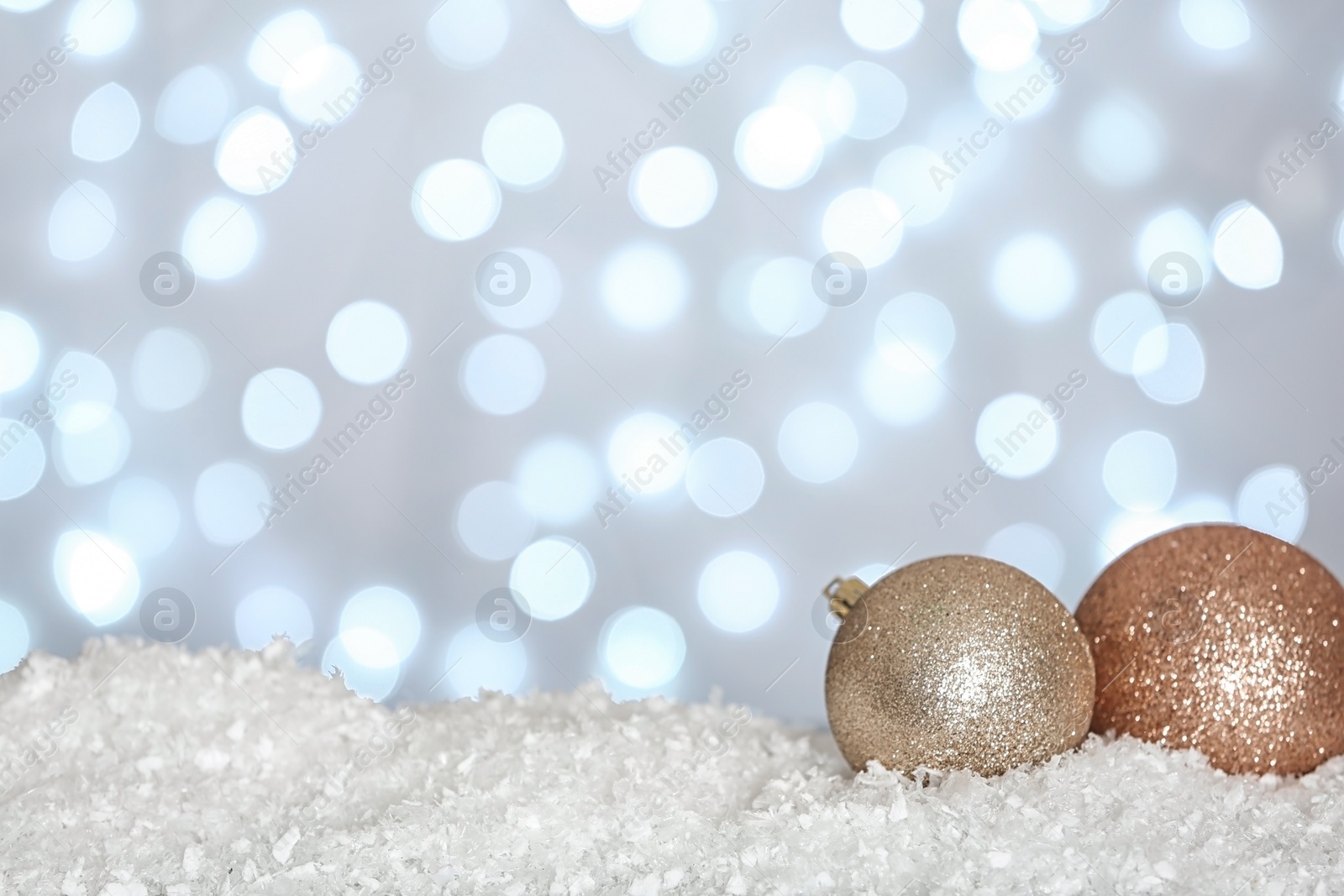 Photo of Christmas decoration on snow against blurred background, space for text