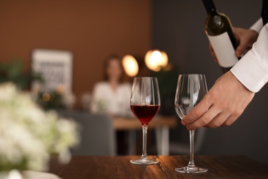 Photo of Man pouring wine into glass in restaurant