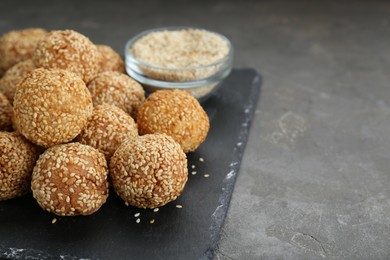 Photo of Delicious sesame balls on grey table, closeup. Space for text