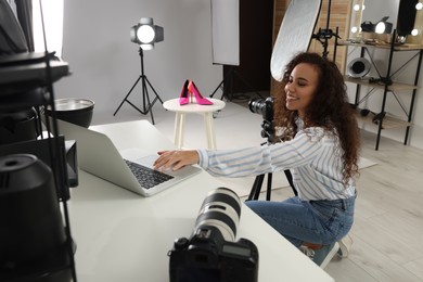 Professional photographer taking picture of stylish shoes in studio