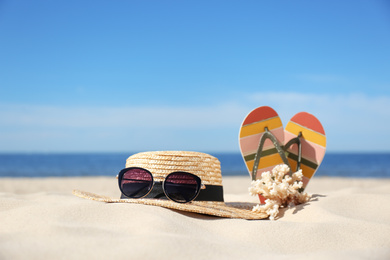 Stylish beach accessories for summer vacation on sand near sea