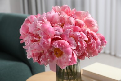 Beautiful bouquet of pink peonies in vase on table indoors, closeup