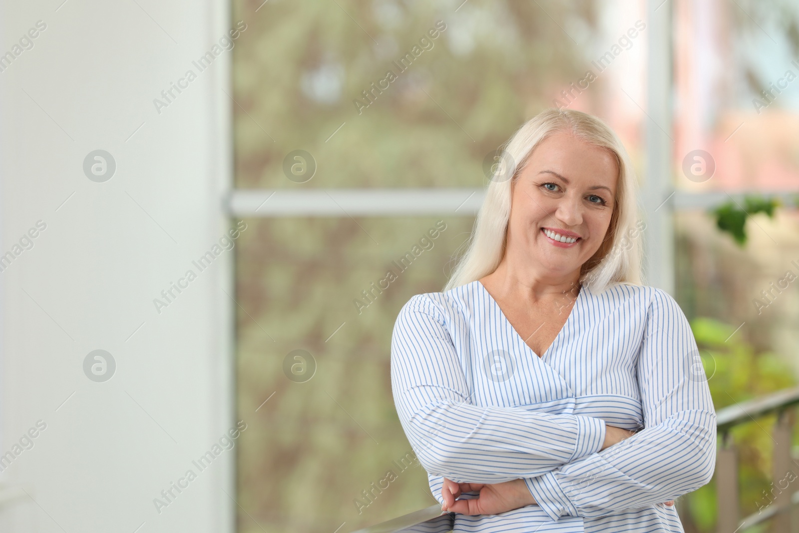 Photo of Portrait of beautiful older woman against blurred background with space for text