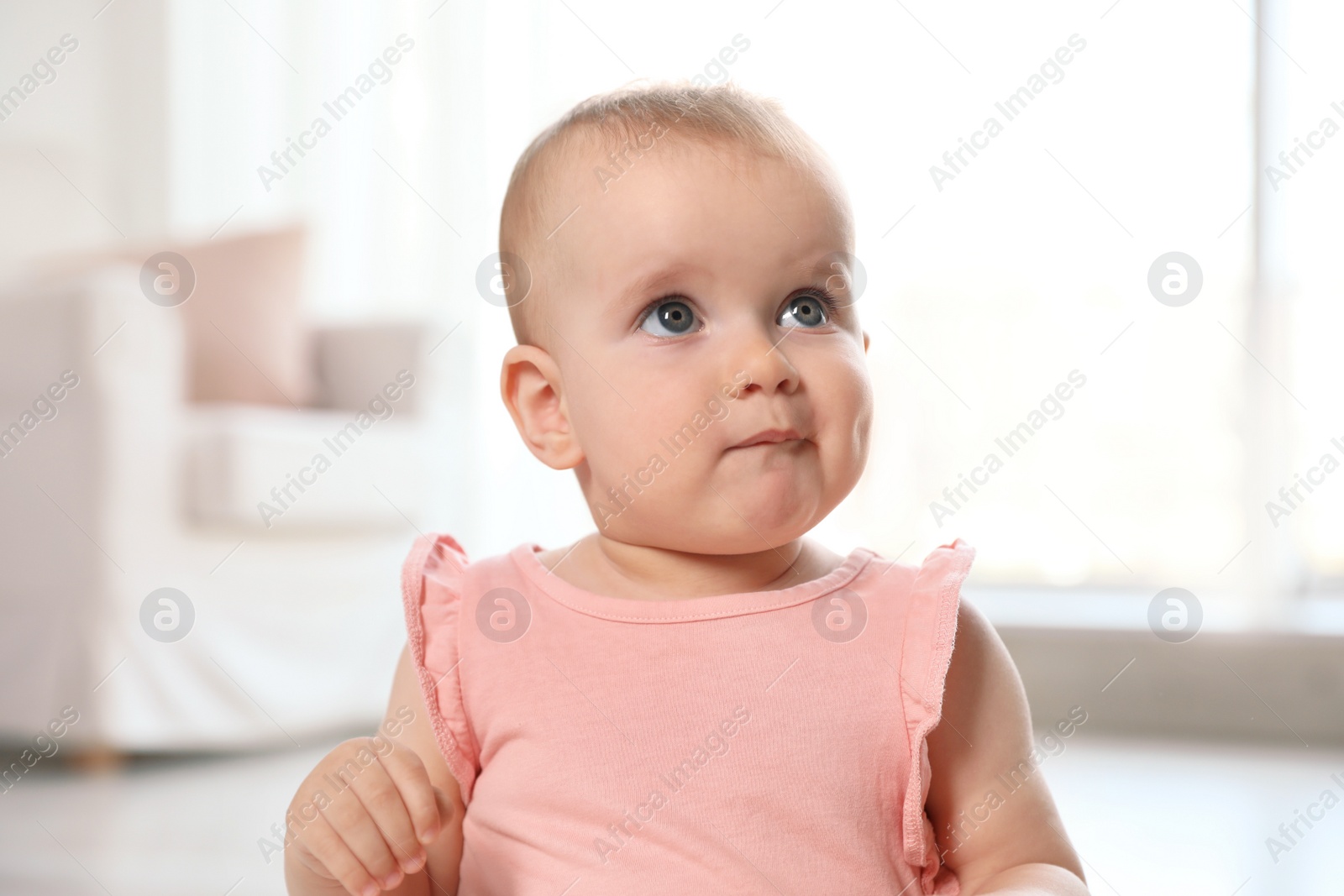 Photo of Portrait of cute baby girl in room