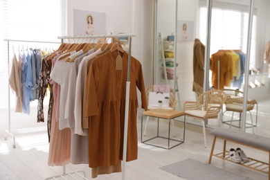 Photo of Stylish women's clothes and accessories in modern boutique