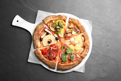 Photo of Slicesdifferent pizzas on grey table, top view
