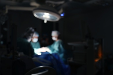 Photo of Blurred view of medical team performing surgery in operating room