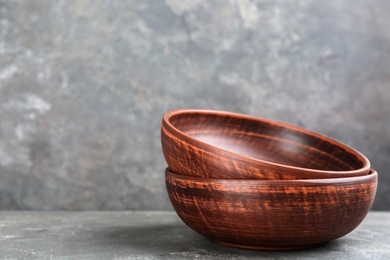 Photo of Clay bowls on grey table, space for text. Handmade utensils