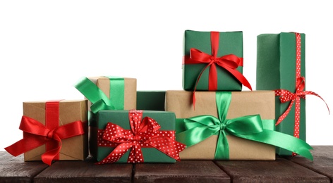 Many different Christmas gifts on wooden table against white background