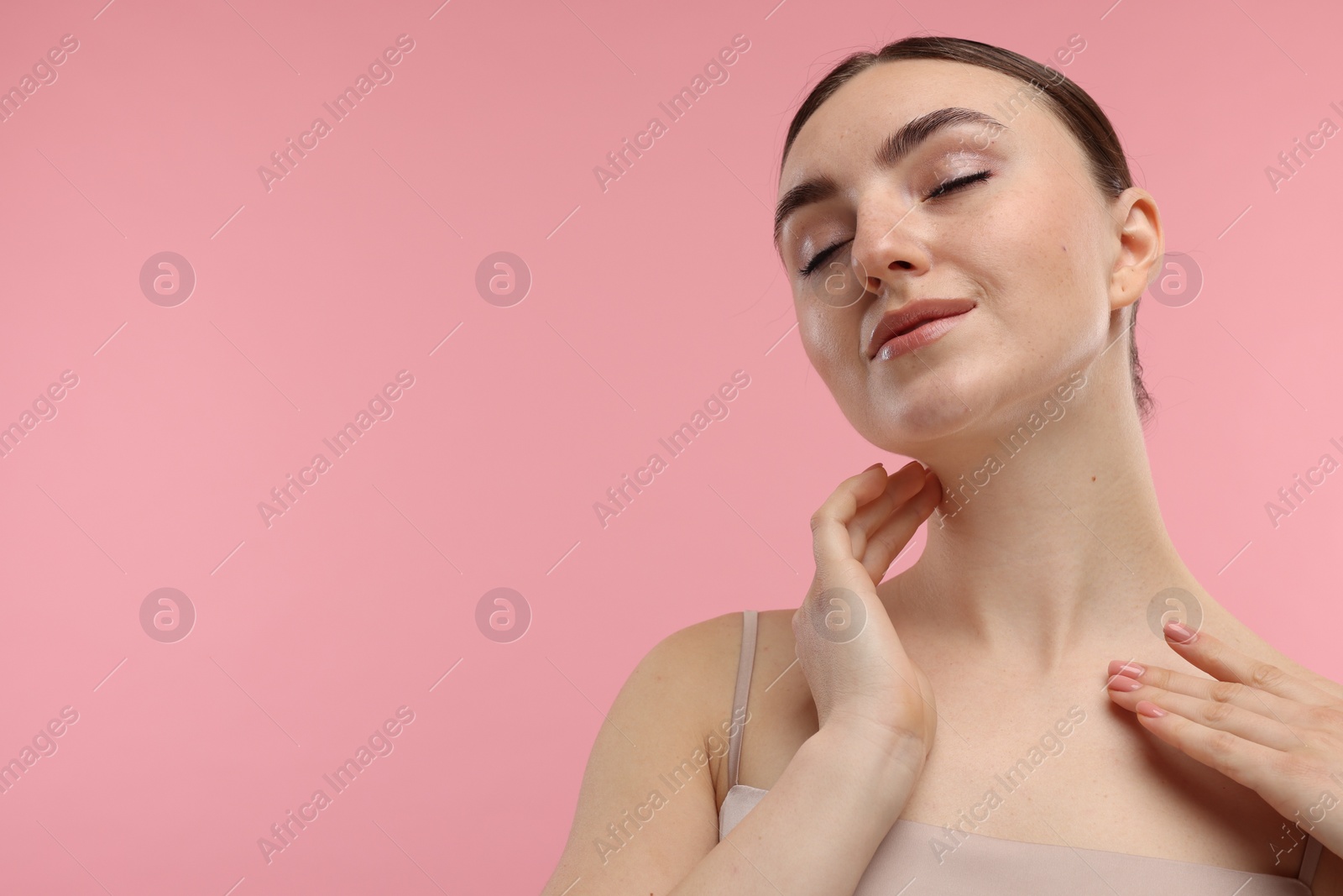 Photo of Beautiful woman touching her neck on pink background. Space for text