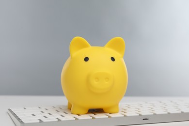 Yellow piggy bank and keyboard on white table