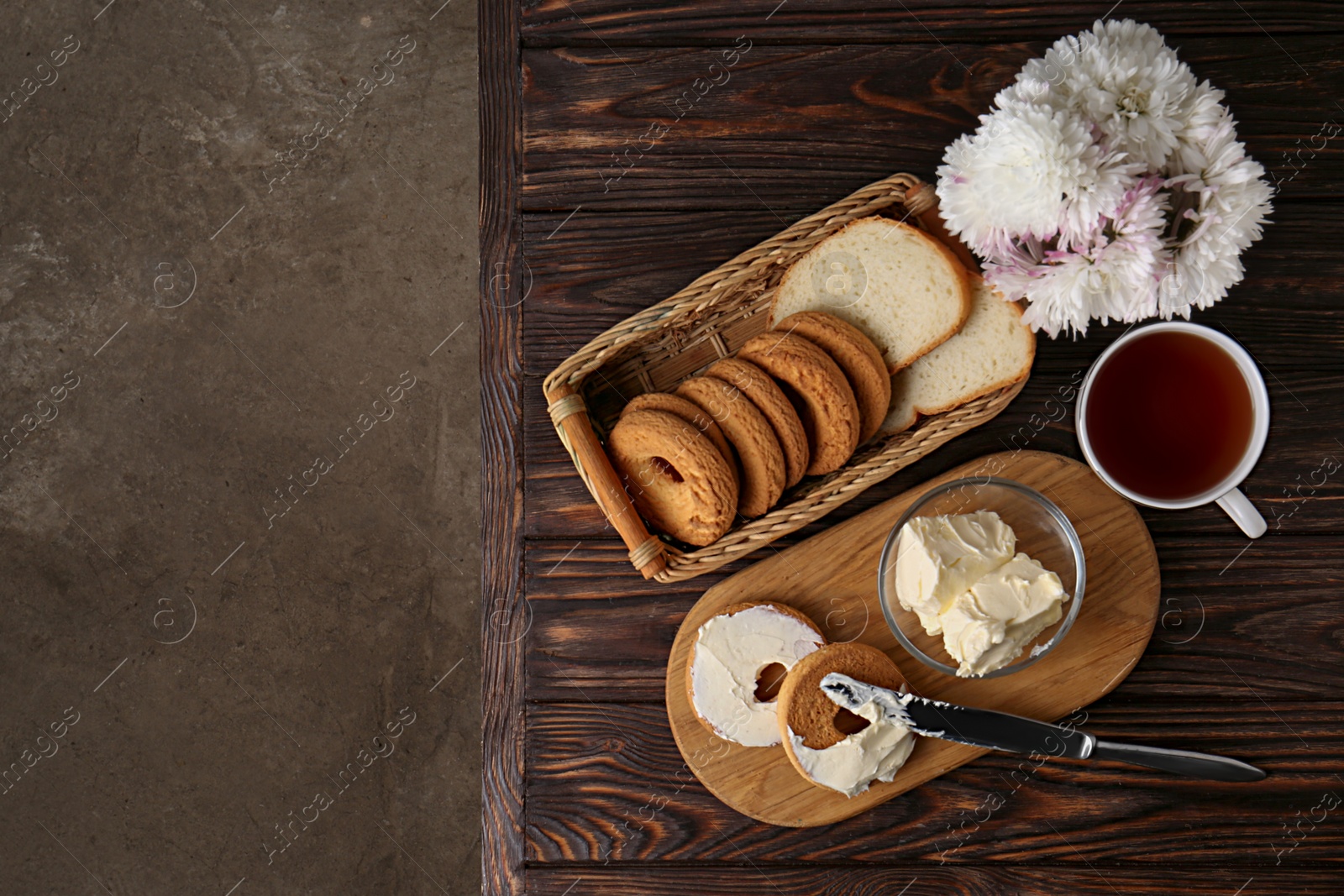 Photo of Tasty homemade butter, cookies and tea on wooden table, flat lay. Space for text