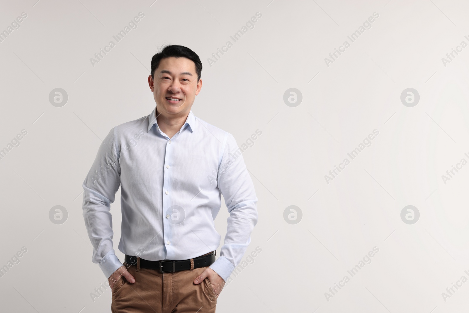 Photo of Portrait of happy man on light background. Space for text