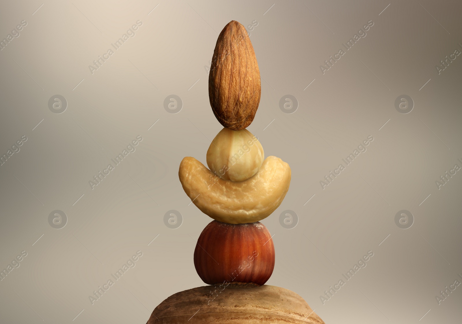 Image of Stacked different nuts on light brownish grey gradient background