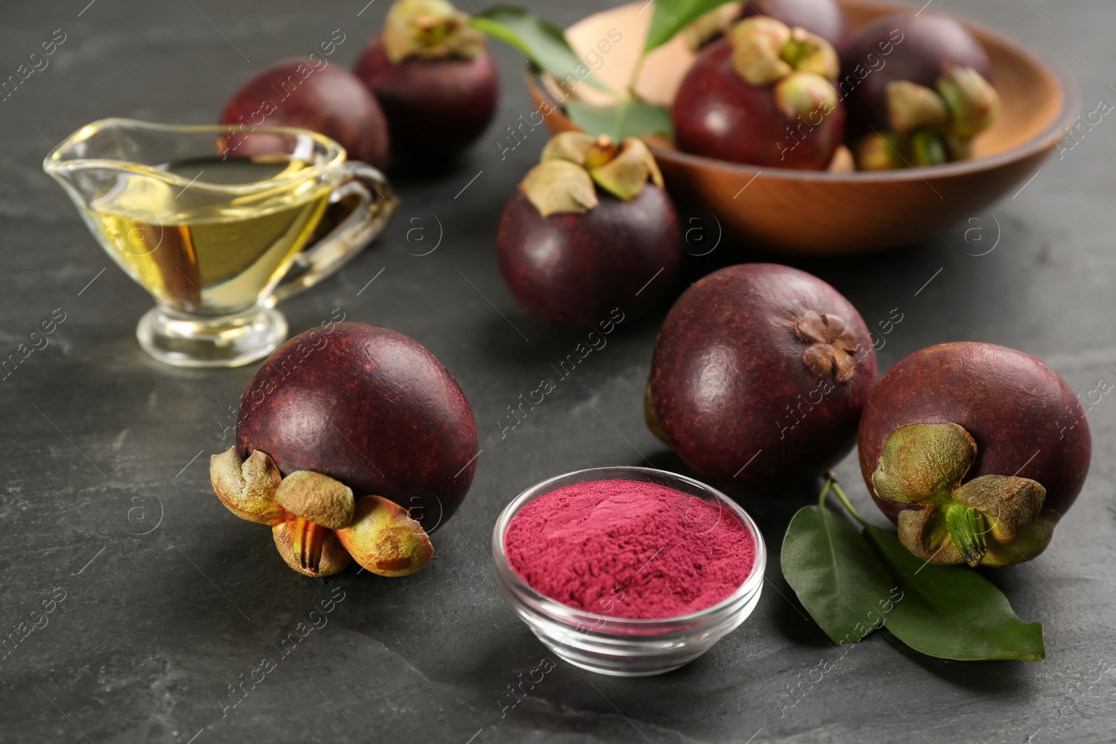 Photo of Purple mangosteen powder and fruits on black table