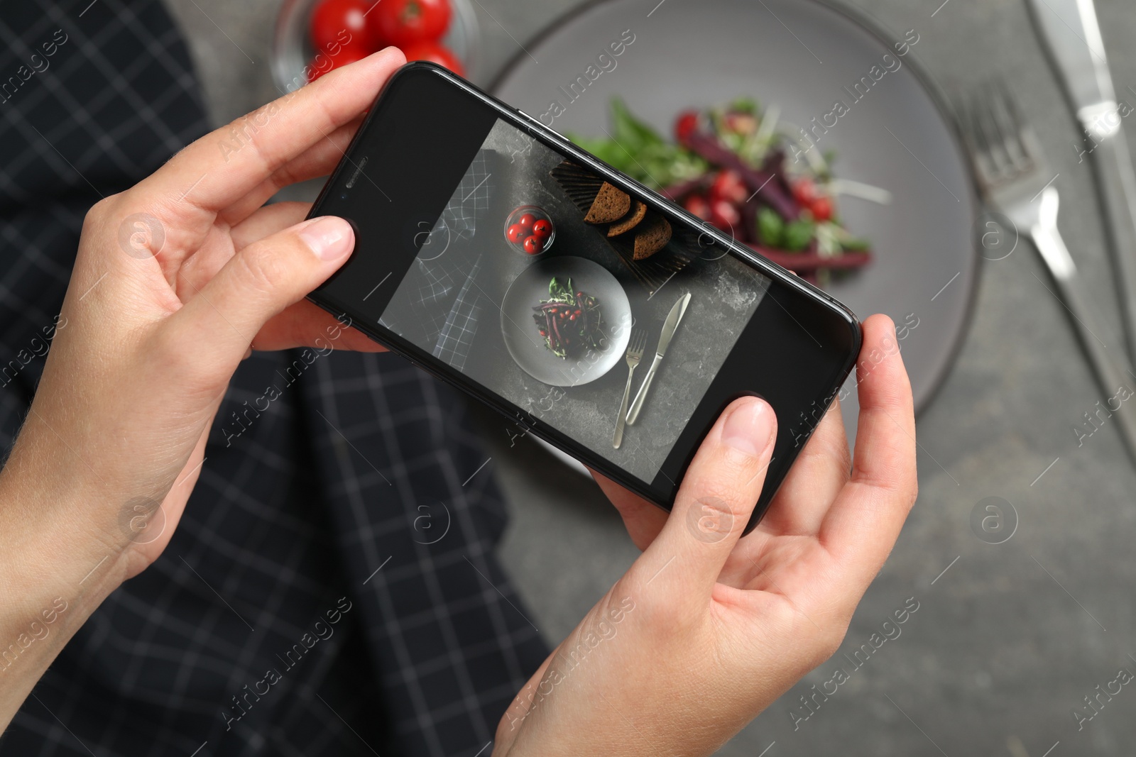 Photo of Blogger taking picture of salad at grey table, top view