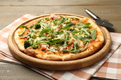 Photo of Board with delicious vegetarian pizza on wooden table, closeup