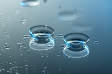 Photo of Pair of contact lenses on wet mirror surface