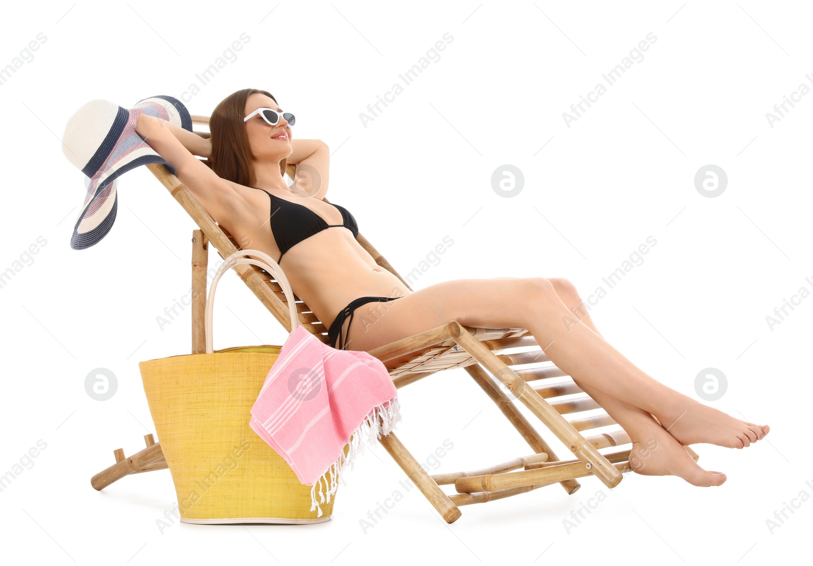 Photo of Young woman with beach accessories on sun lounger against white background