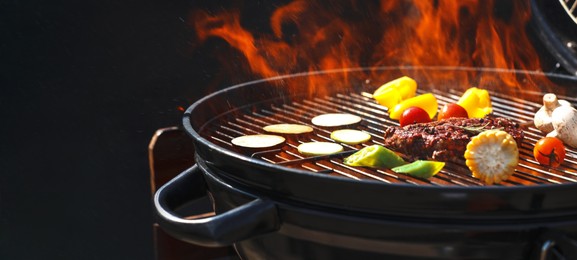 Image of Tasty steak and vegetables on burning barbecue grill, closeup. Banner design