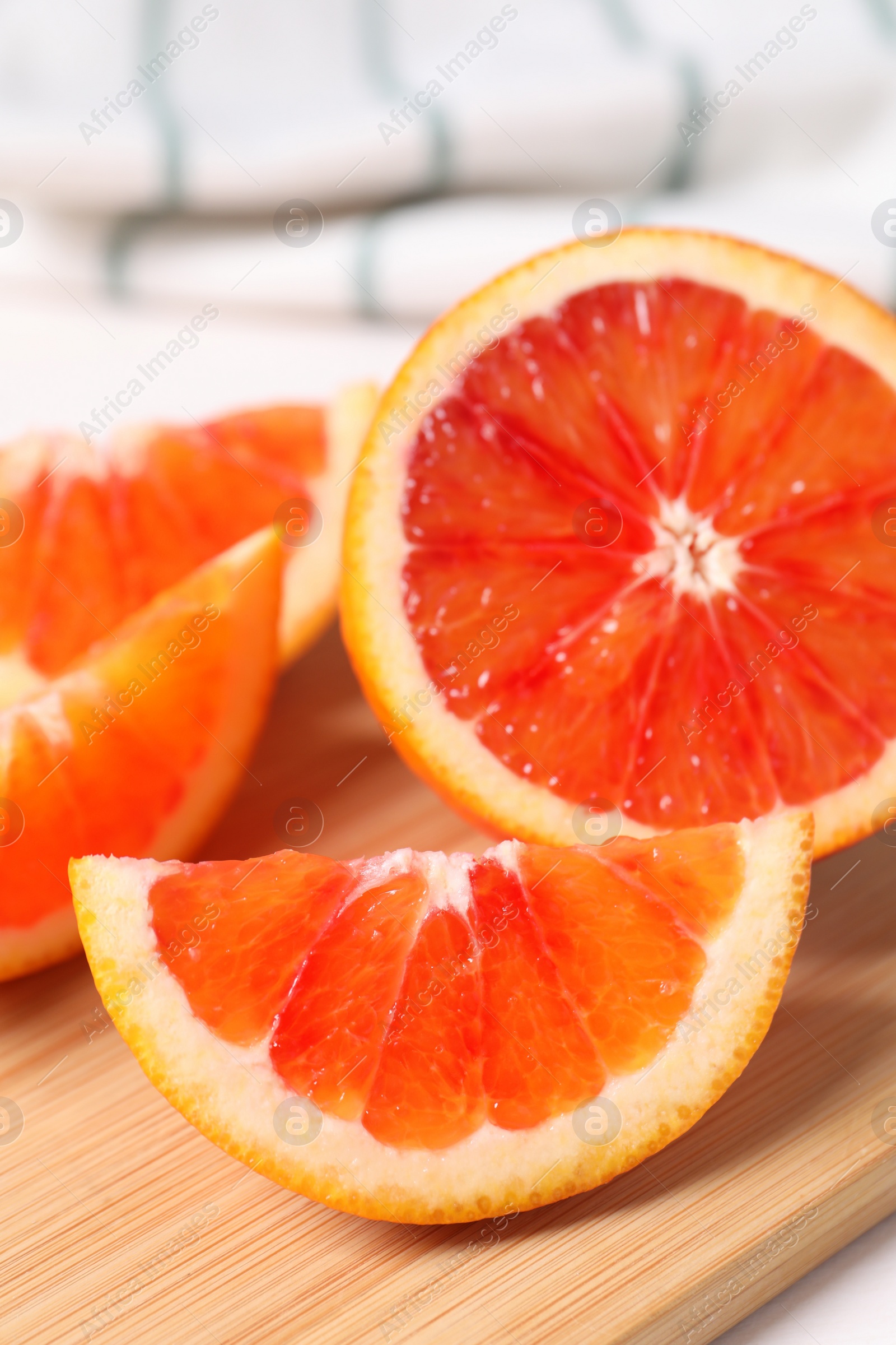 Photo of Slices of red orange on wooden board, closeup