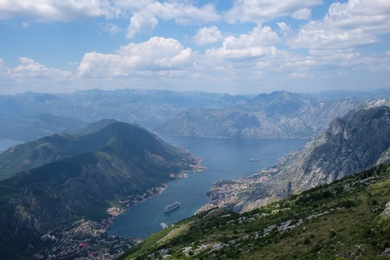 Image of Picturesque view of beautiful bay between mountains under blue sky with clouds