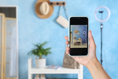 Blogger taking photo of shelving unit with stylish shoes indoors, closeup. Space for text