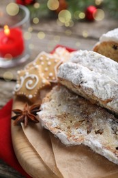 Photo of Traditional Christmas Stollen with icing sugar on wooden table, closeup