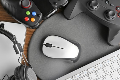 Flat lay composition with computer mouse and gaming gear on table