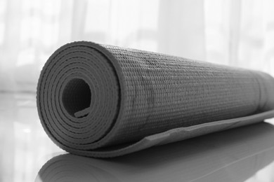 Rolled karemat or fitness mat on floor indoors, closeup