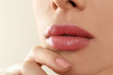 Photo of Woman with beautiful full lips on beige background, closeup