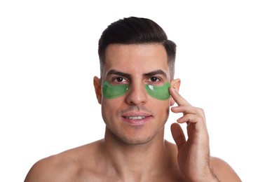 Man applying green under eye patch on white background