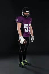 Photo of American football player with ball on dark background