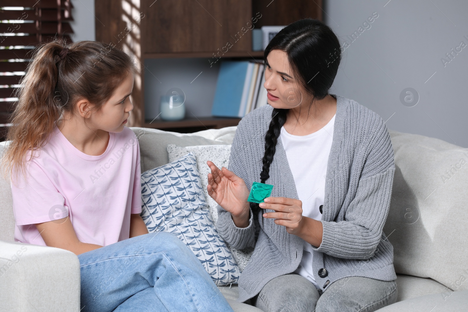 Photo of Mother talking with her teenage daughter about contraception at home. Sex education concept