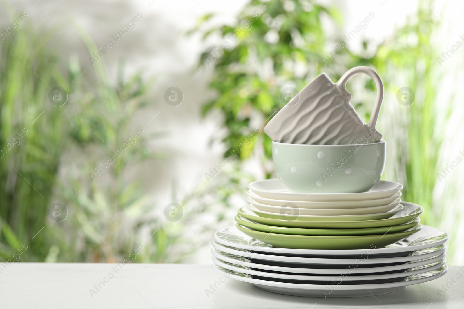 Photo of Beautiful ceramic dishware and cup on white table outdoors, space for text