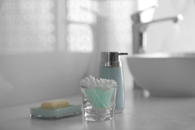 Photo of Cotton buds and soap on white countertop