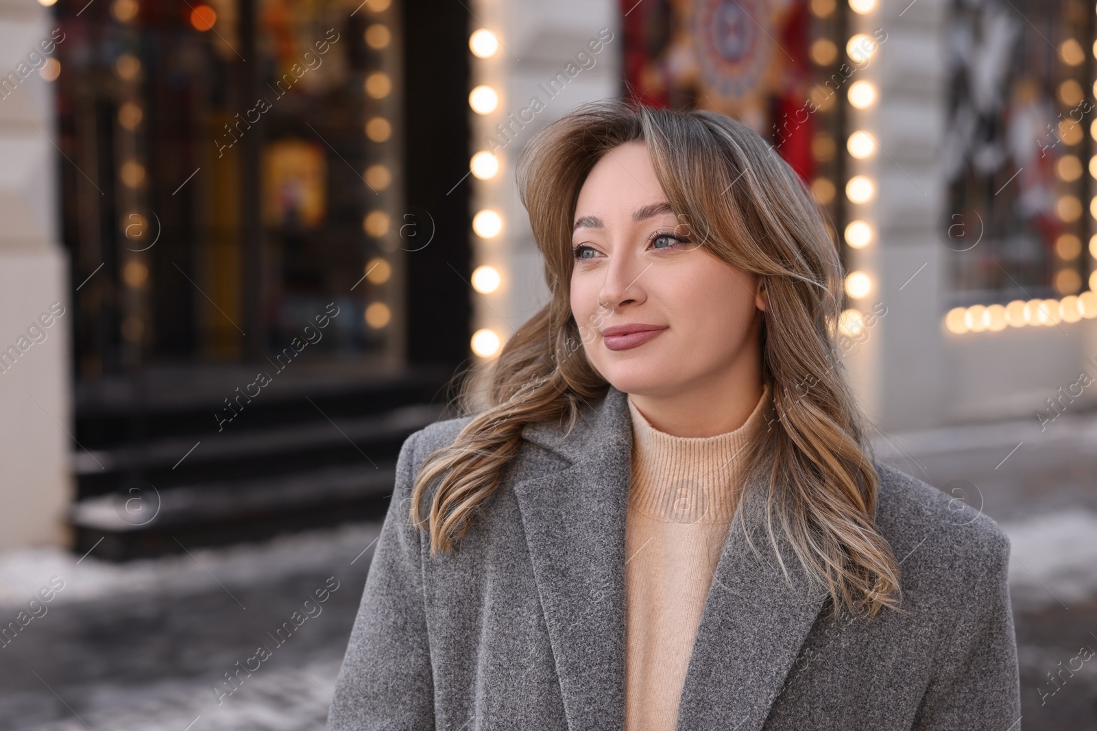 Photo of Portrait of charming woman on city street in winter. Space for text