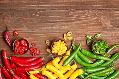 Photo of Flat lay composition with chili peppers on wooden background