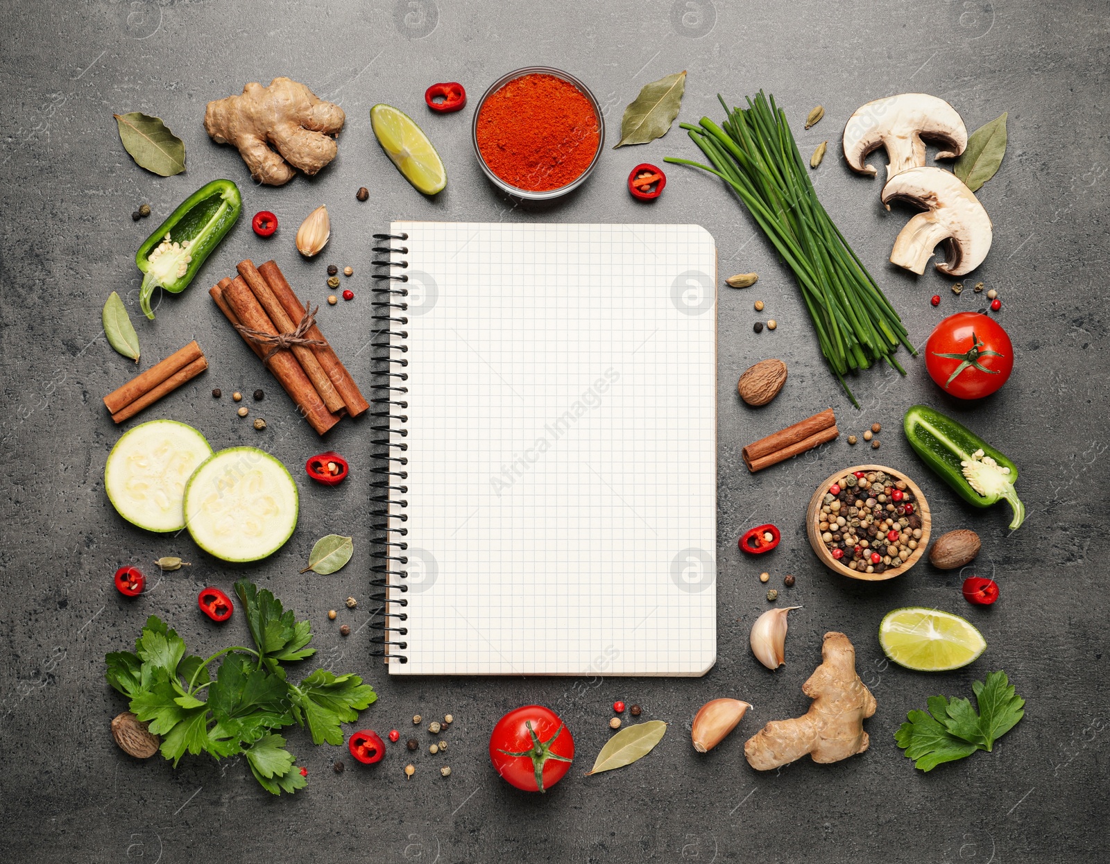 Photo of Blank recipe book and different ingredients on grey table, flat lay. Space for text