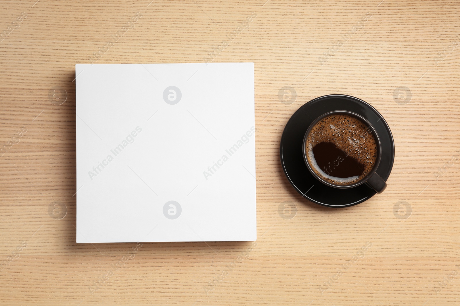 Photo of Blank paper sheets for brochure and cup of coffee on wooden background, flat lay. Mock up