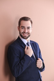 Portrait of young businessman with beautiful hair on color background