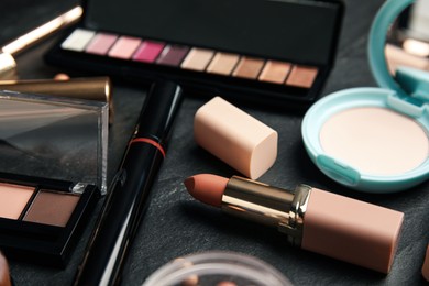 Photo of Different makeup products on black slate table