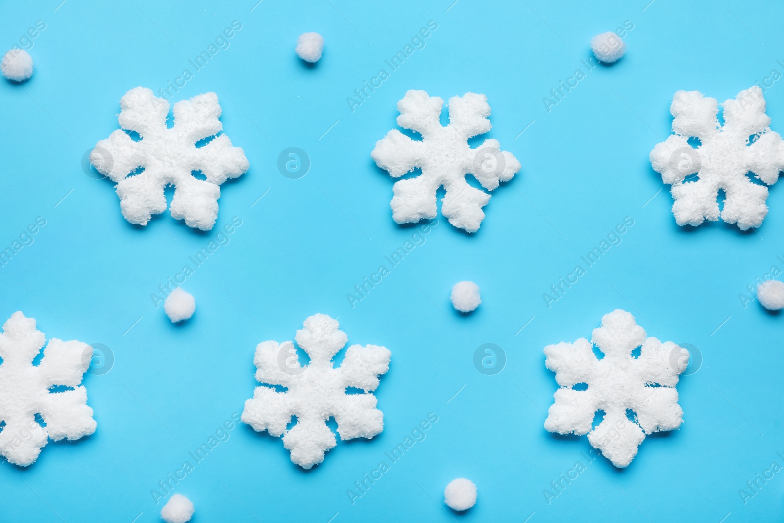 Photo of Beautiful decorative snowflakes on light blue background, flat lay