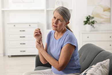 Photo of Arthritis symptoms. Woman suffering from pain in wrist at home