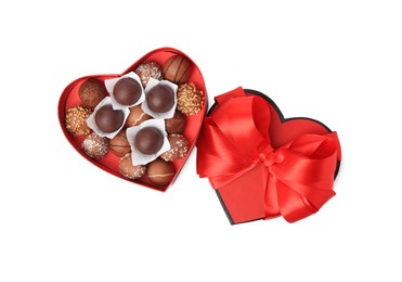 Photo of Heart shaped box with delicious chocolate candies isolated on white, top view