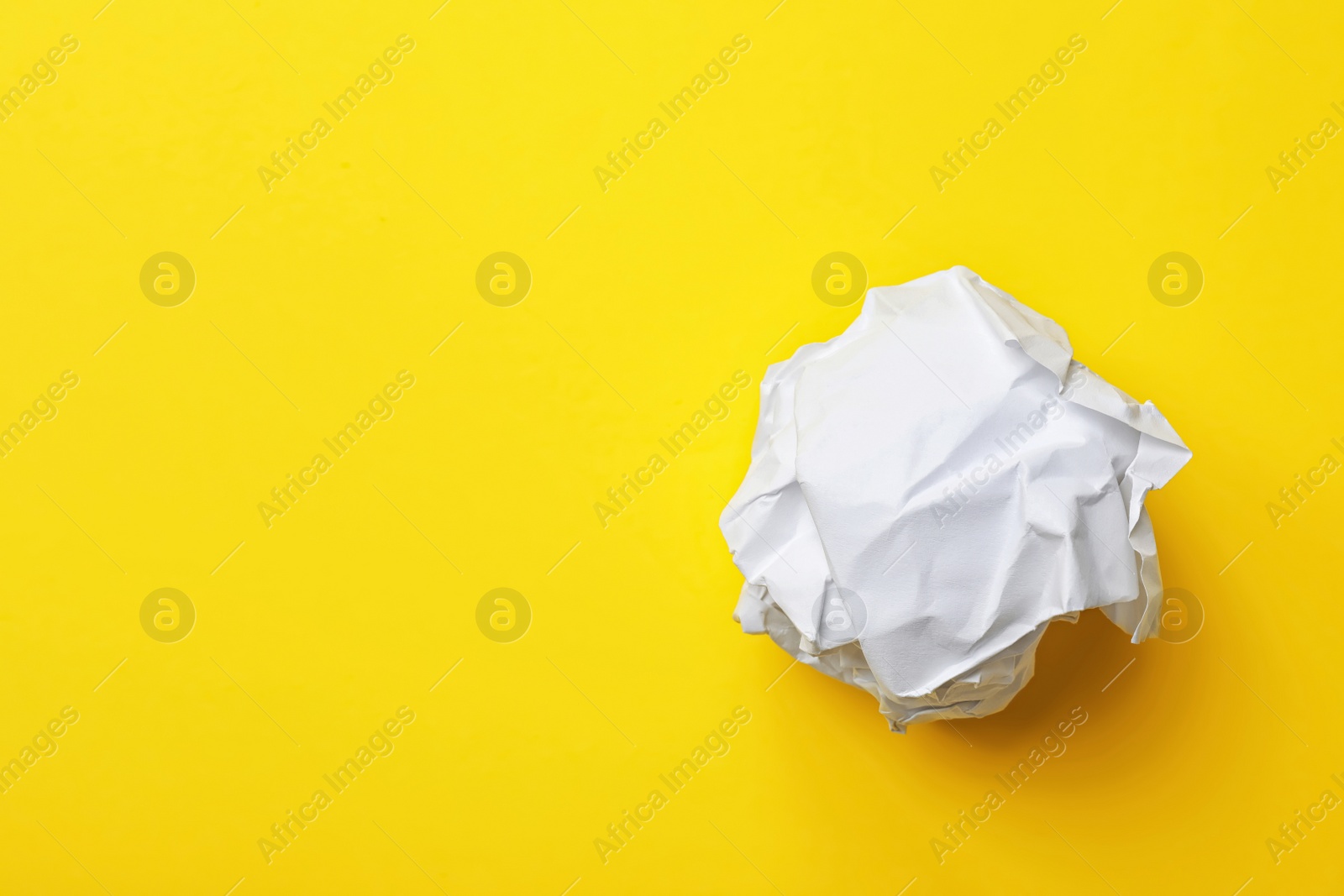 Photo of Crumpled sheet of paper on color background, top view. Space for text