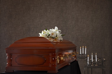 Photo of Wooden casket with white lilies in funeral home